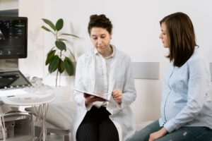 A woman consulting a doctor about reasons why an ultrasound is needed before an abortion.
