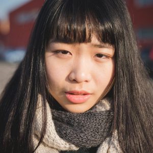 portrait young woman looking camera outdoor city serious - pensive, worry, sadness concept